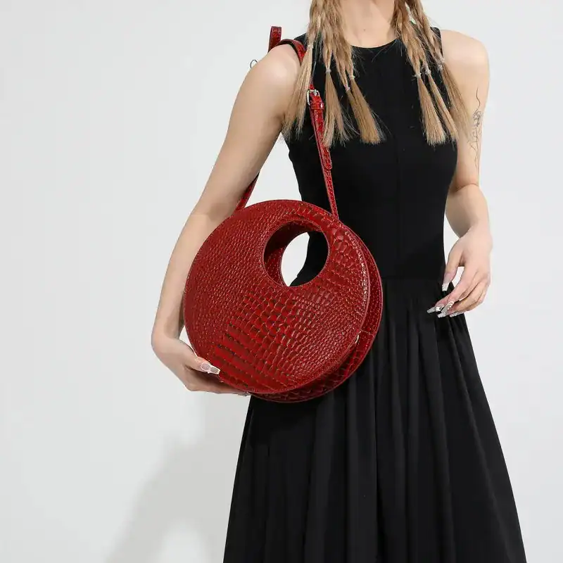 Röd rund väska med hål, axelväska i krokodiltextur, modeaccessoarer.