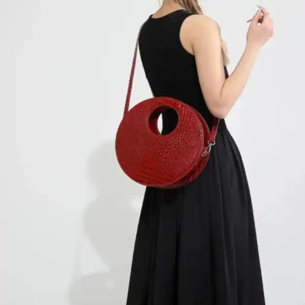 Röd rund väska med hål, axelväska i röd vävad textil, modeaccessoarer.