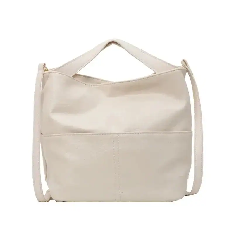 Rymlig beige väska med axelrem och handtag, perfekt för vardag och shopping.