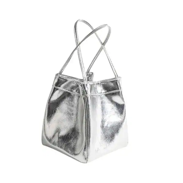 Silver hinkväska med korsade handtag och metallisk yta.