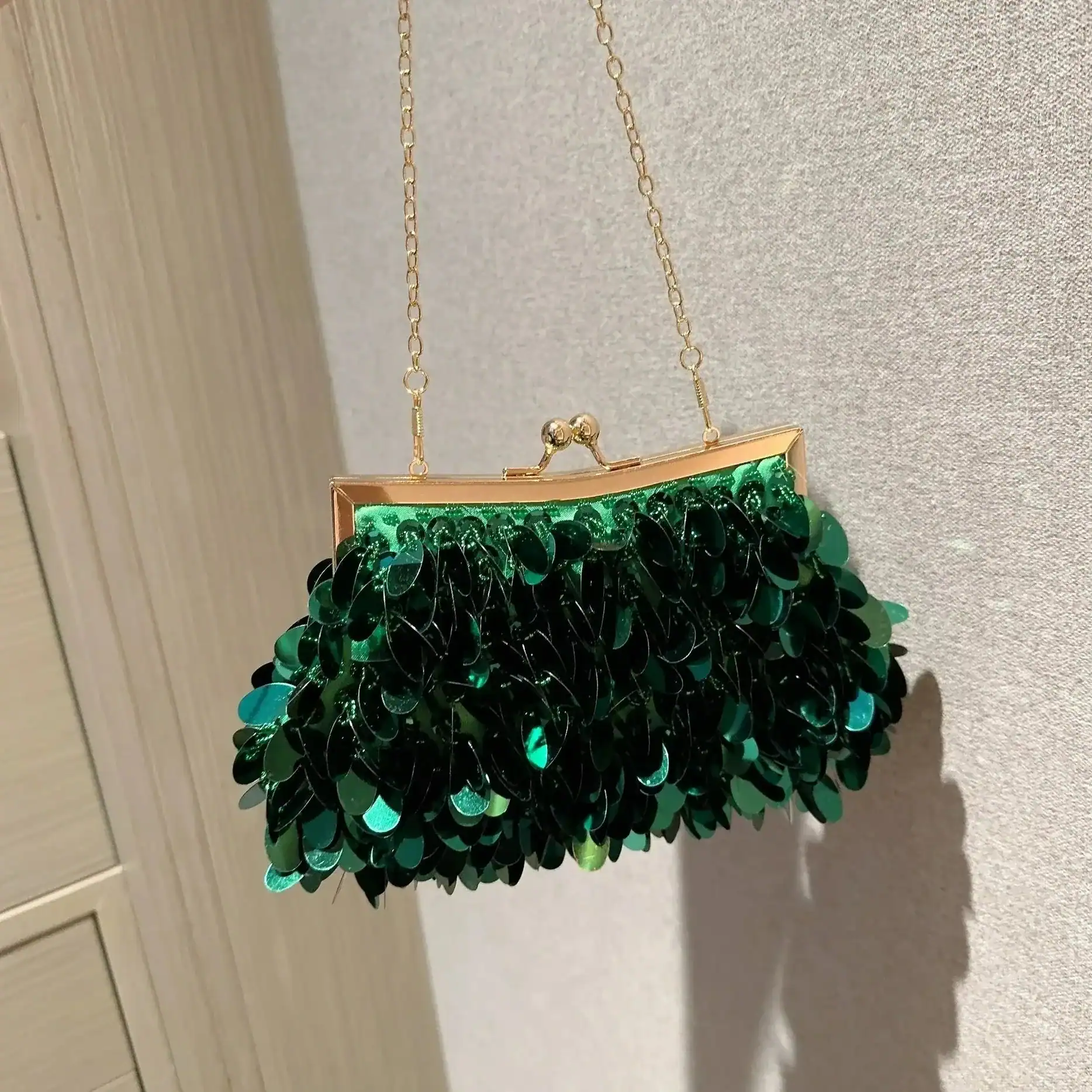 Grön glittrande paljettclutch med guld kedja och kisslock.