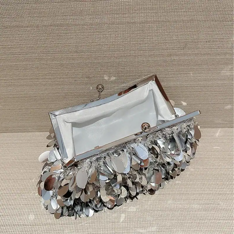 Silver paljettclutch med speglar och metalliskt design.