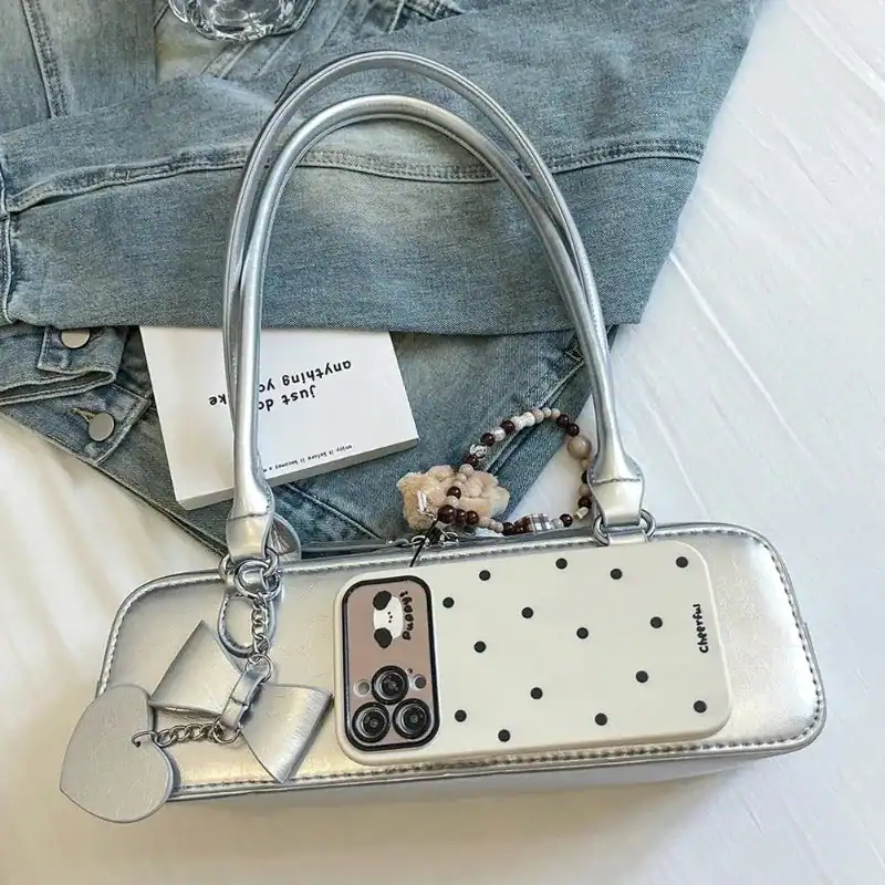 Silvrig axelremsväska med prickig design och mobilfack, passar till jeans.