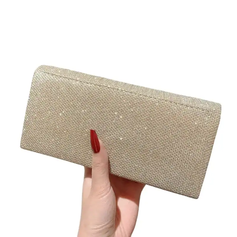 Silvrig glitterclutch i hand, elegant och perfekt för festliga tillfällen.