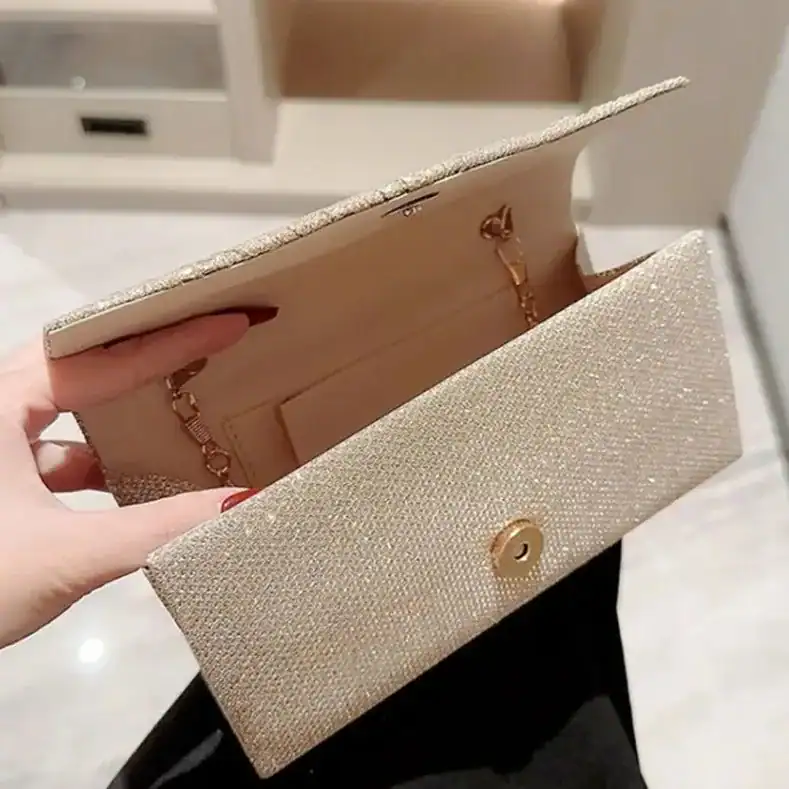 Silvrig glitterclutch med guld detaljer och inre plånboksfack.