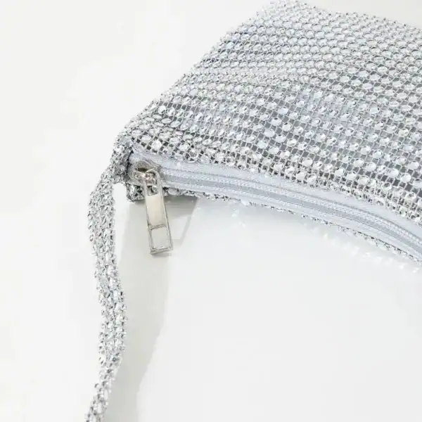 Silvrig kuvertväska med strass och dragkedja, perfekt för fest och kväll.