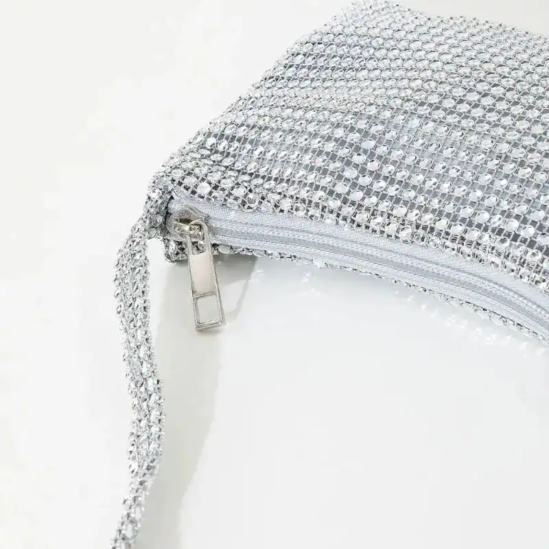 Silvrig kuvertväska med strass och dragkedja, perfekt för fest och kväll.
