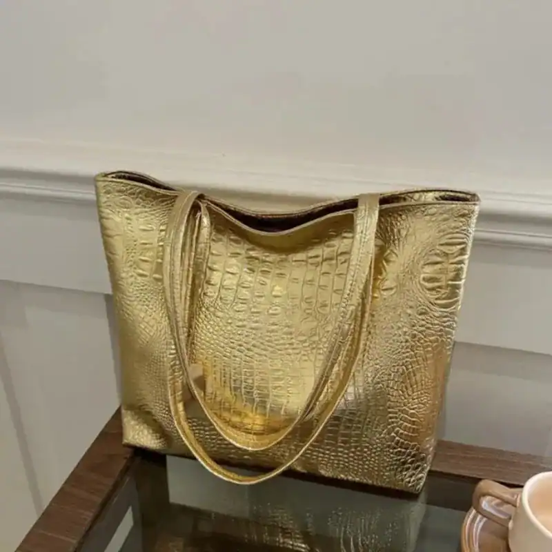 Silvrig väska med krokodilsmönster, elegant axelväska i guldtoner.