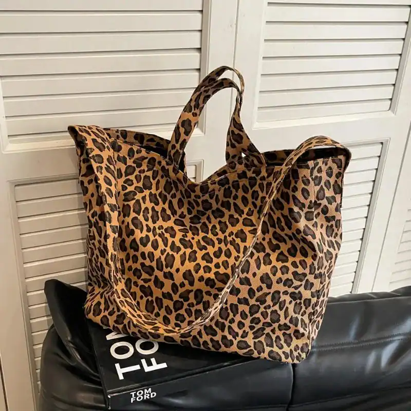 Stor leopard shoppingväska i beige och svart, plånboksbag med handtag.