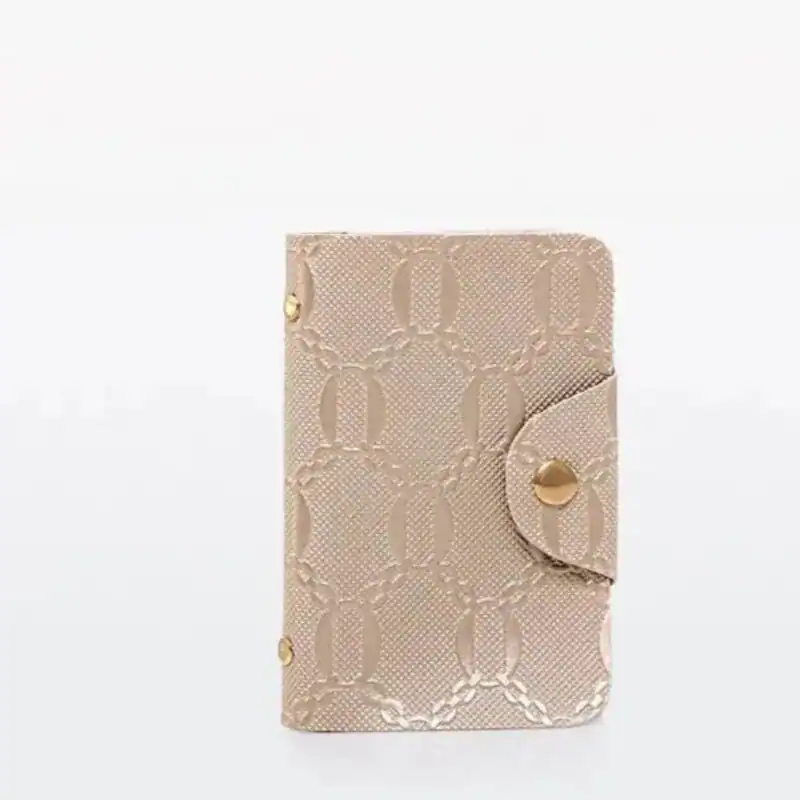 Stor handväska i beige med guldtonad detalj och mönster.