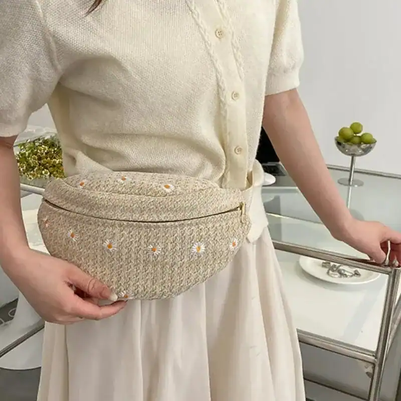 Stråmidjeväska med daisy-mönster, beige färg, bärtas på midjan.