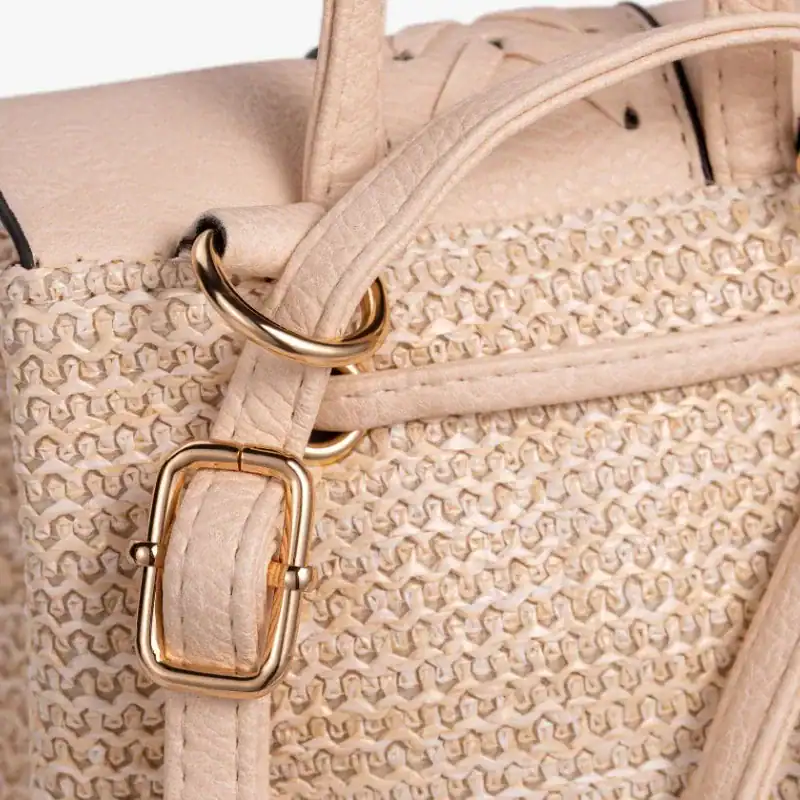 Stråryggsäck med tofs, beige färg, guld detaljer och texturerad yta.