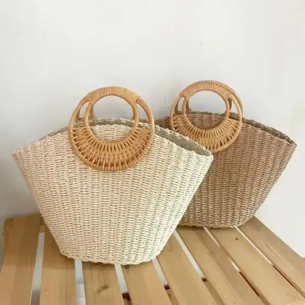Stråväska med rundade handtag i beige och naturfärg, perfekt för sommar och strand.