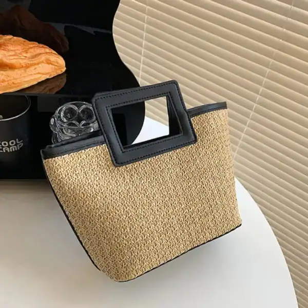 Svart beige flätad väska med rektangulär handtag, lämplig för sommar och strand.