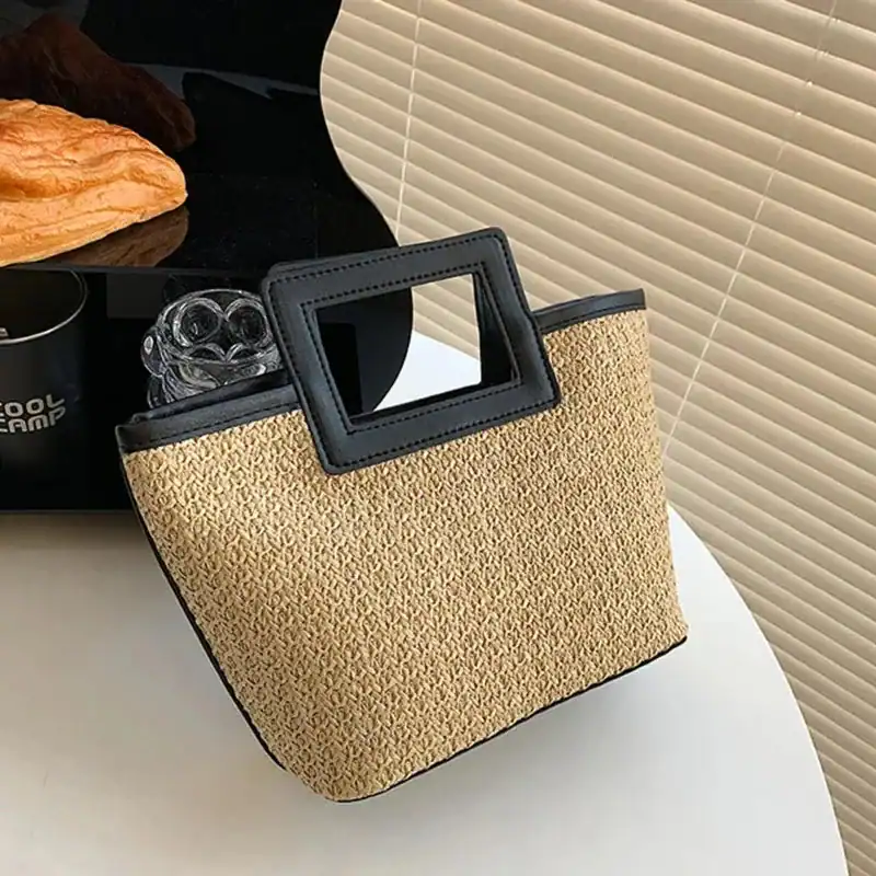 Svart beige flätad väska med rektangulär handtag, lämplig för sommar och strand.