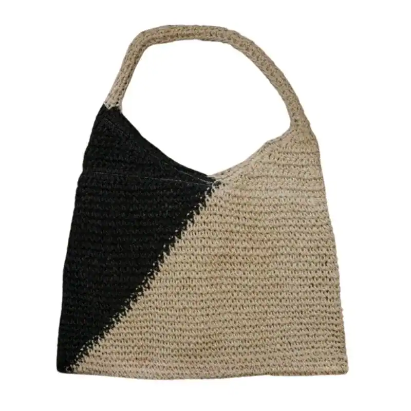 Svart beige virkad väska med diagonalt mönster och runt handtag.