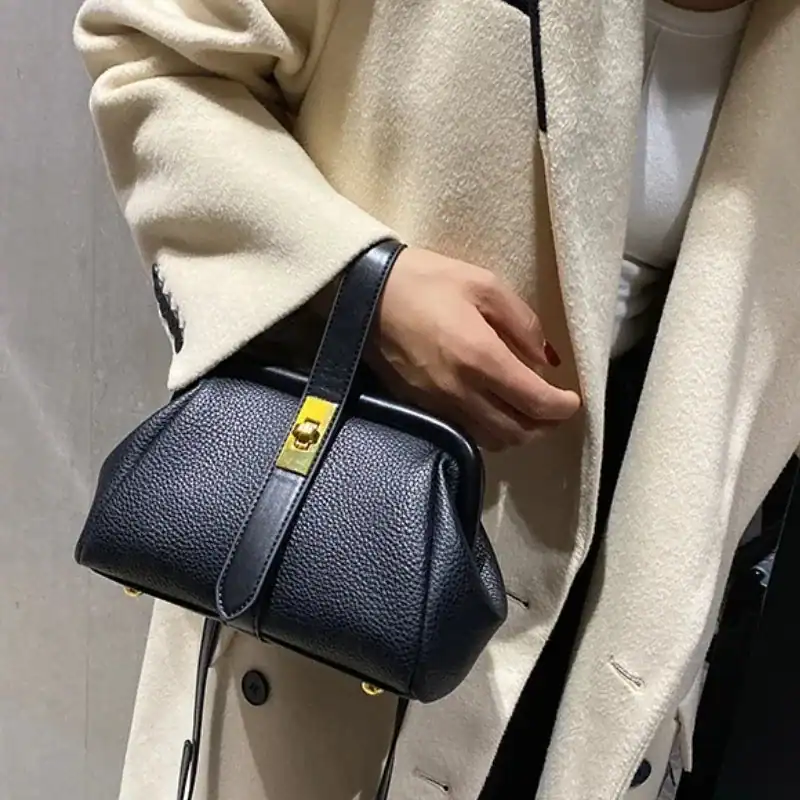 Svart doktorsväska med guldaccent, läder, handväska, modeaccessoarer.