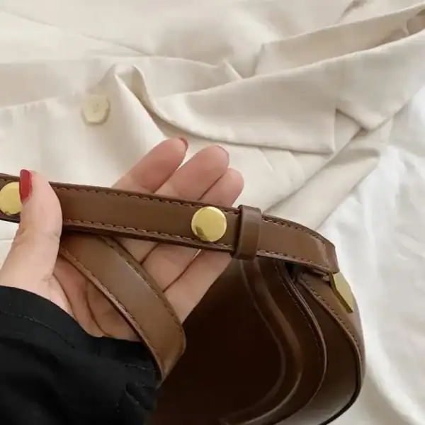Svart halvmåneväska med lock, läder, guldtonad knapp, handtag, modeväska.