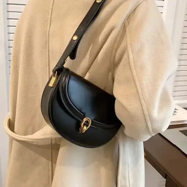Svart halvmåneväska med lock, elegant axelväska i läder för vardag och stil.