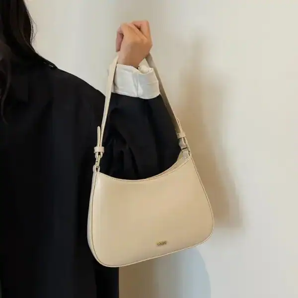 Svart halvmånsväska i läder, modeväska med axelrem, elegant och minimalistisk design.