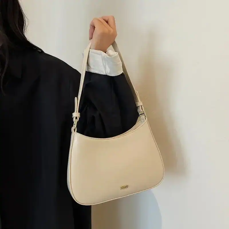 Svart halvmånsväska i läder, modeväska med axelrem, elegant och minimalistisk design.