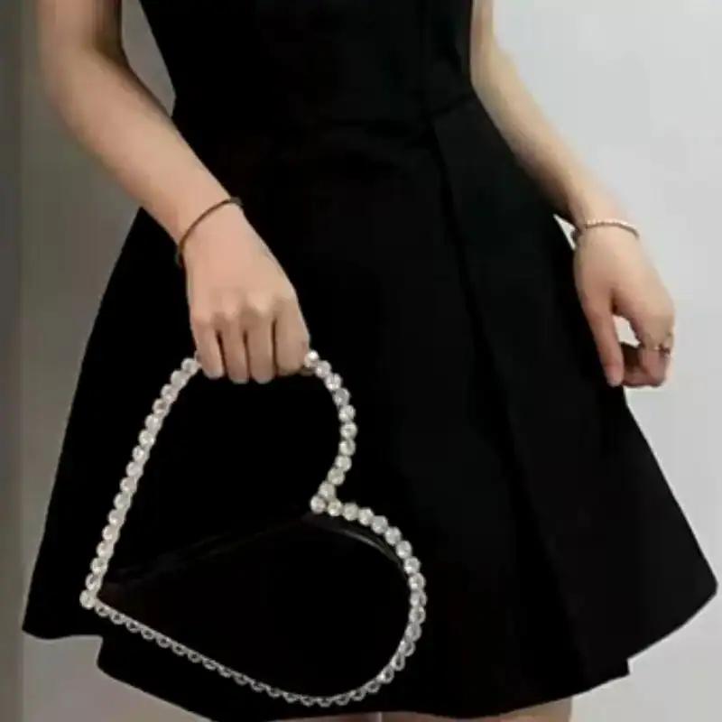 Svart hjärtformad clutch med strass och silverfärgad handtag.