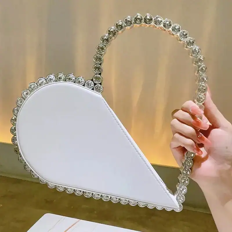 Svart hjärtformad clutch med strass och elegant handtag.