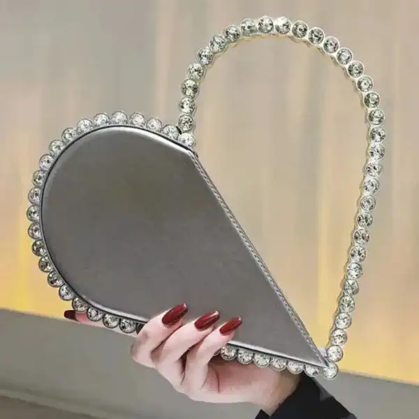 Svart hjärtformad clutch med strass och silverfärgad handtag.