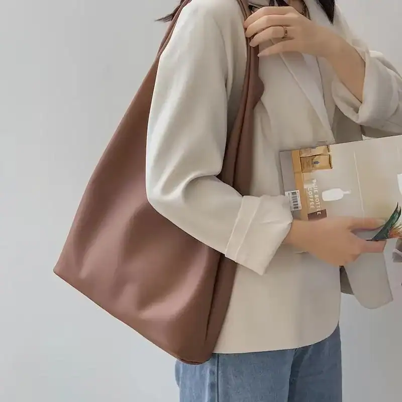 Svart hobo väska, stilfull axelväska i läderliknande material, perfekt för vardag och shopping.