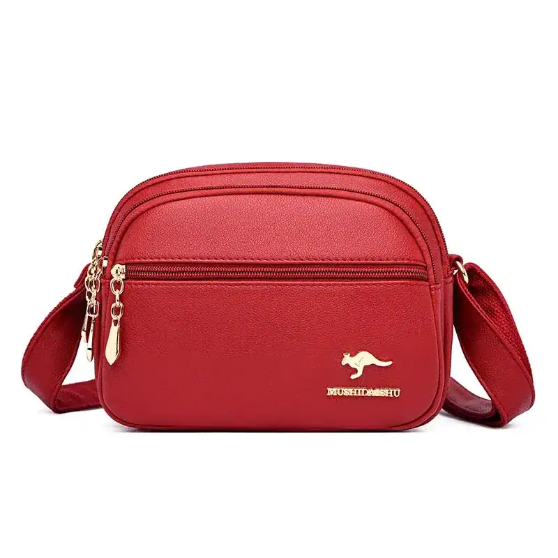 Röd liten crossbody väska med guld detaljer och metalldetalj.