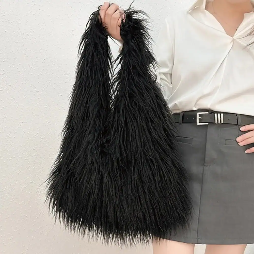 Svart lurvig väska med långt pälsliknande hängande detalj, modeaccessoarer.