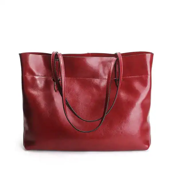 Svart mjuk shopper med långt handtag, läderliknande material och elegant design.