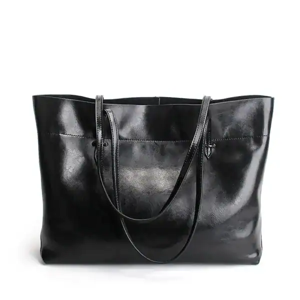 Svart mjuk shopper med långt handtag, läderliknande material och elegant design.