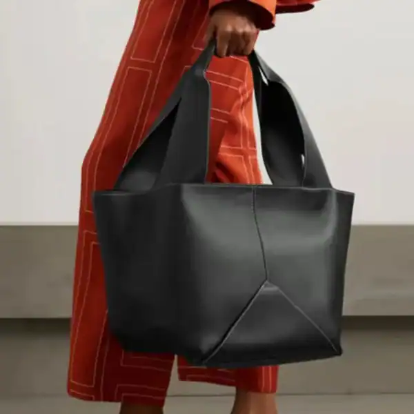 Svart mjuk shoppingväska med stora handtag, mode och stil.