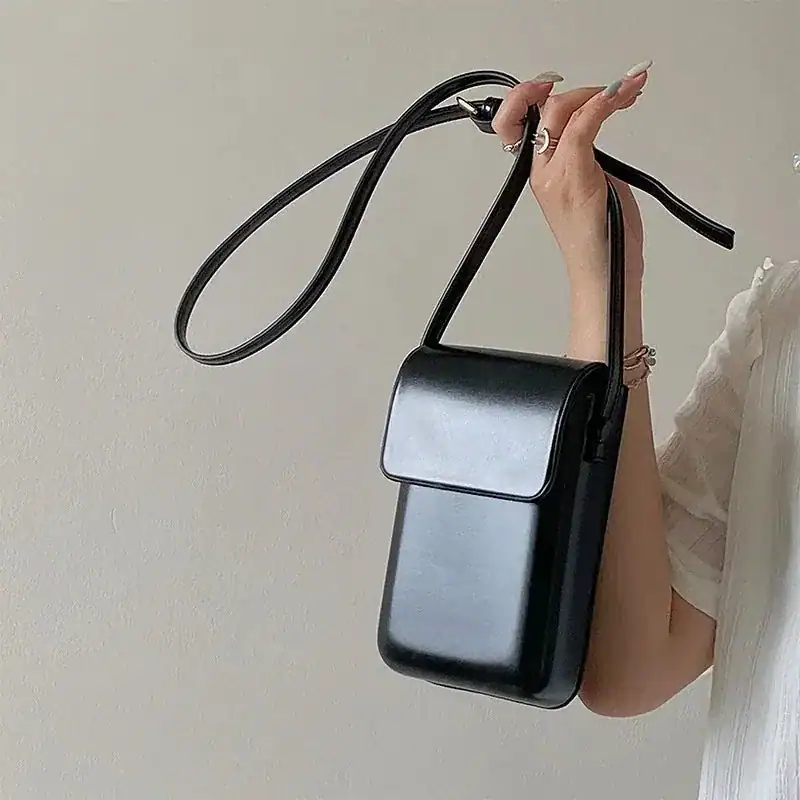 Svart mobilväska med axelrem, minimalistisk design för daglig användning.