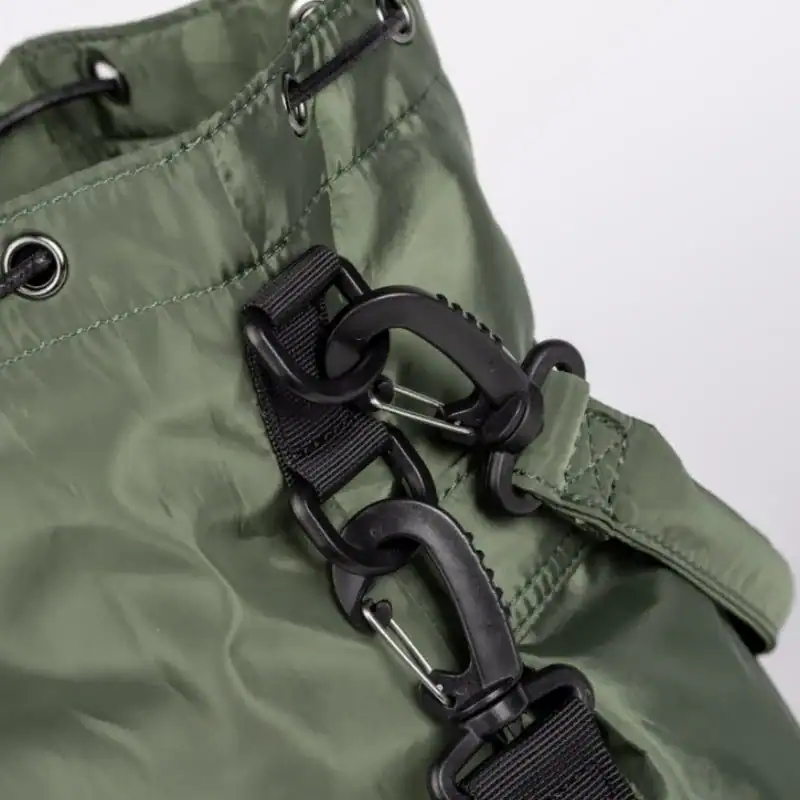 Svart nylon hinkväska med karabiner och dragkedja.