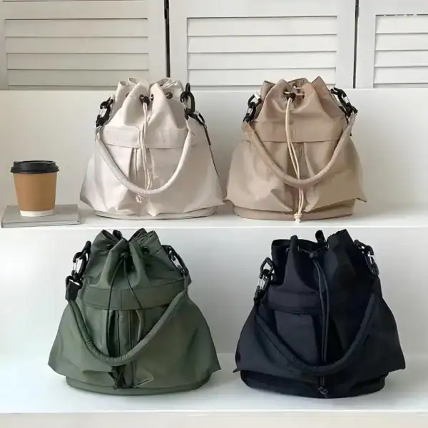Svart nylon hinkväska i olika färger, trendig axelväska med dragkedja och skulderrem.