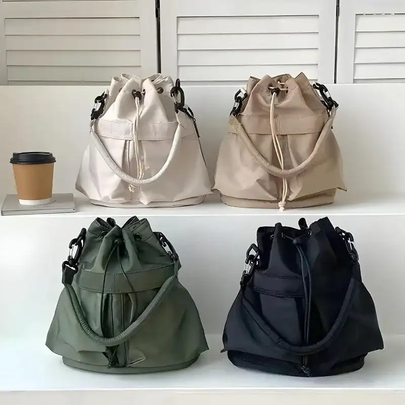 Svart nylon hinkväska i olika färger, trendig axelväska med dragkedja och skulderrem.