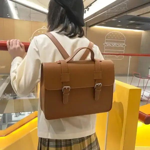 Svart rektangulär skolväska med ryggsäckdesign, lämplig för skola och arbete.