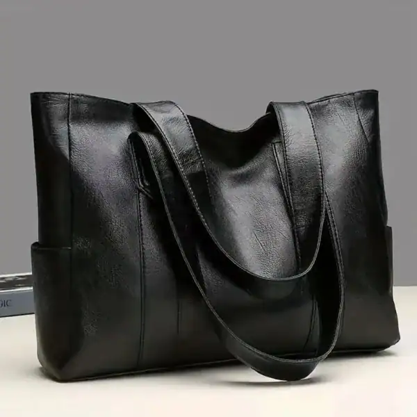 Svart läder tote bag med långt handtag, elegant och praktisk axelväska för vardag.