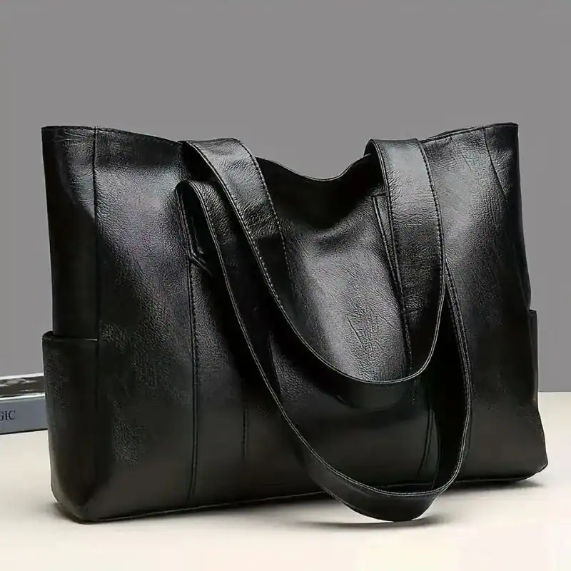 Svart läder tote bag med långt handtag, elegant och praktisk axelväska för vardag.