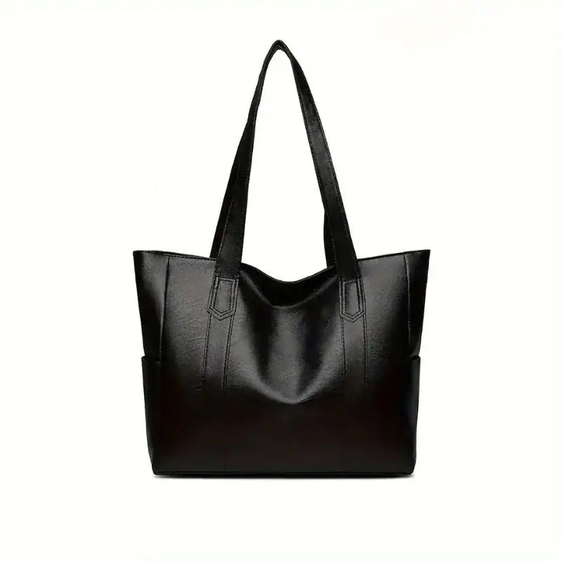 Svart tote bag med långt handtag och elegant design för vardag och stil.