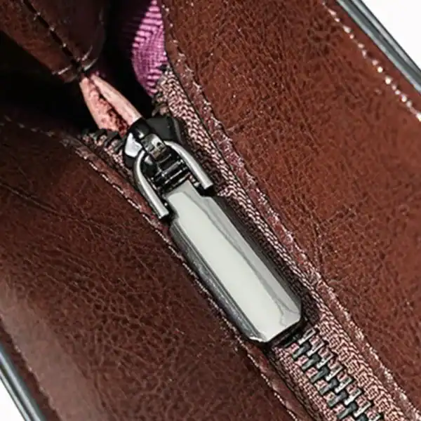 Svart tote shoppingväska med metallisk dragkedja och läderdetaljer.