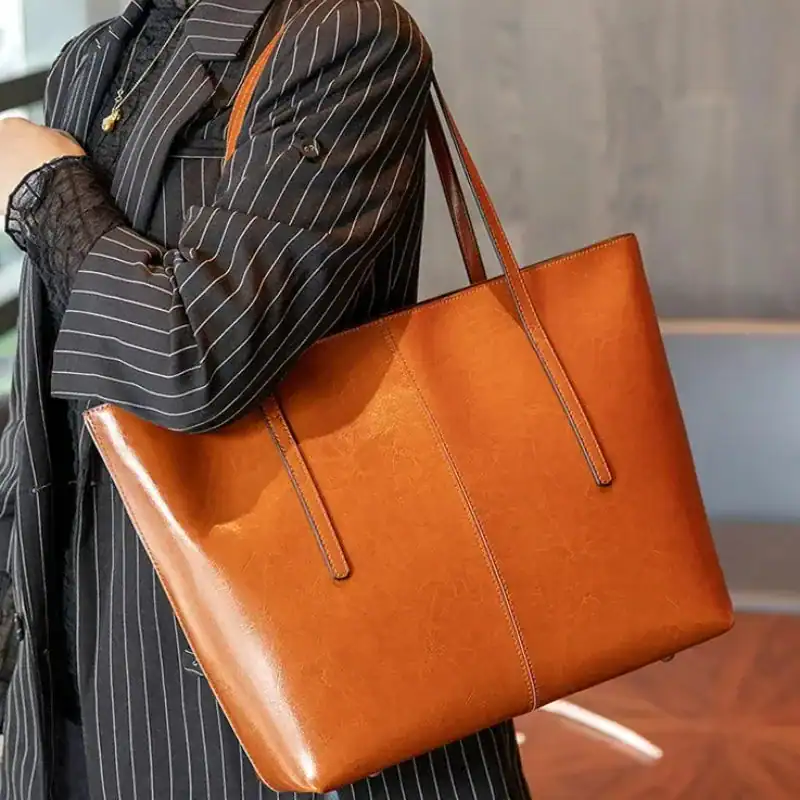 Svart tote shoppingväska med långt handtag, elegant och praktisk för vardag.