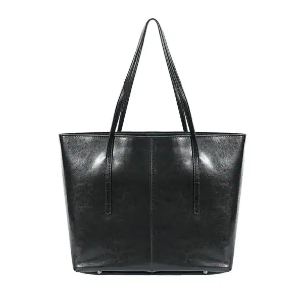 Svart tote shoppingväska med långt handtag, läderliknande material.