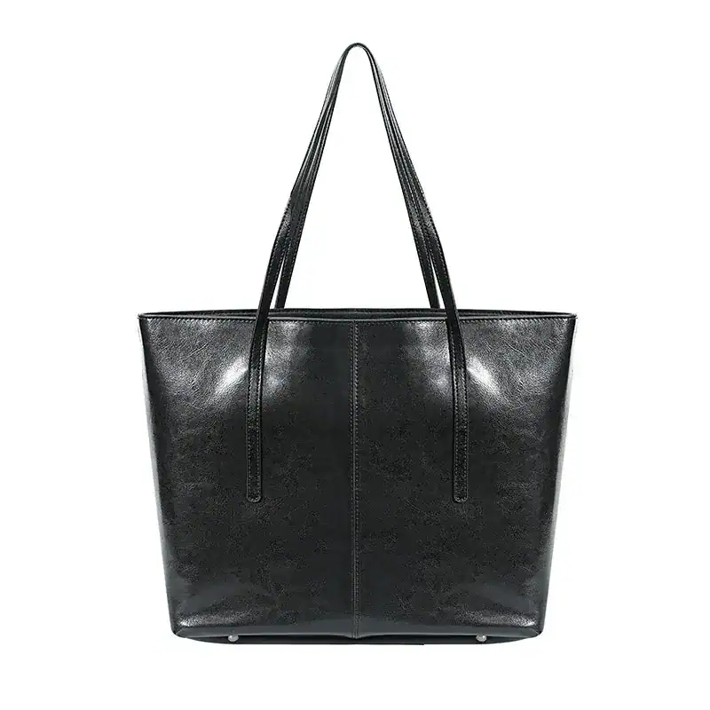 Svart tote shoppingväska med långt handtag, läderliknande material.