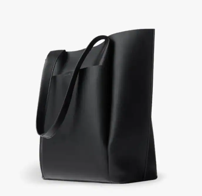 Svart tygshoppingväska med långa handtag, stilren och praktisk för daglig användning.