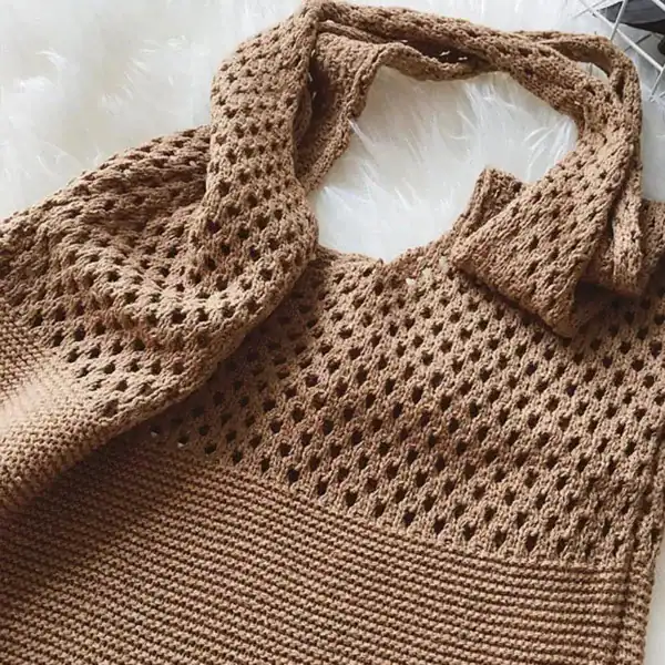 Svart tygväska triangel, handstickad axelväska i beige med öppen struktur och lång axelrem.