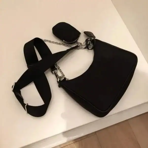 Svart Axelväska med kedjehandtag och justerbar axelrem.
