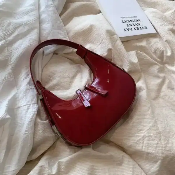 Vinröd lack halvmånsväska med silverfärgad snabbficka och handtag.